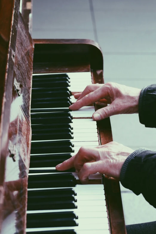 two hands are playing a piano together