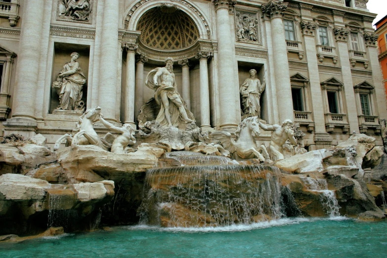 several people standing around statues near a fountain