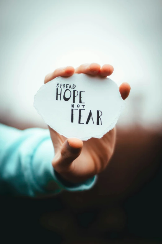 a person is holding up a piece of paper that says i need hope at a fear