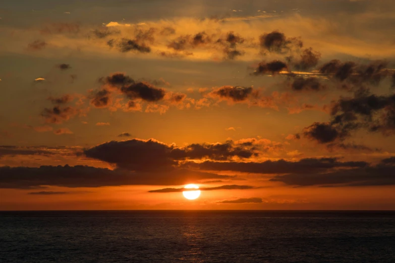 a large body of water under a bright sunset