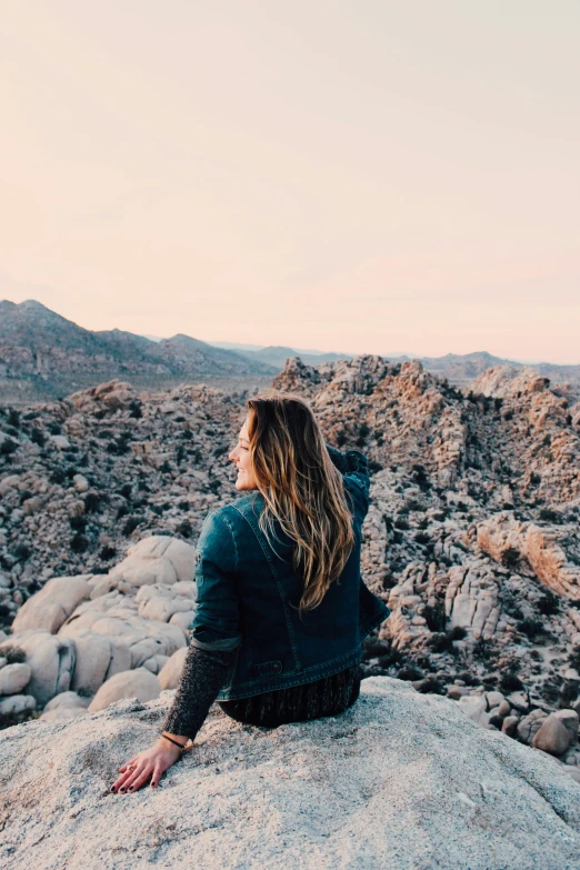 a person sitting on top of a rock