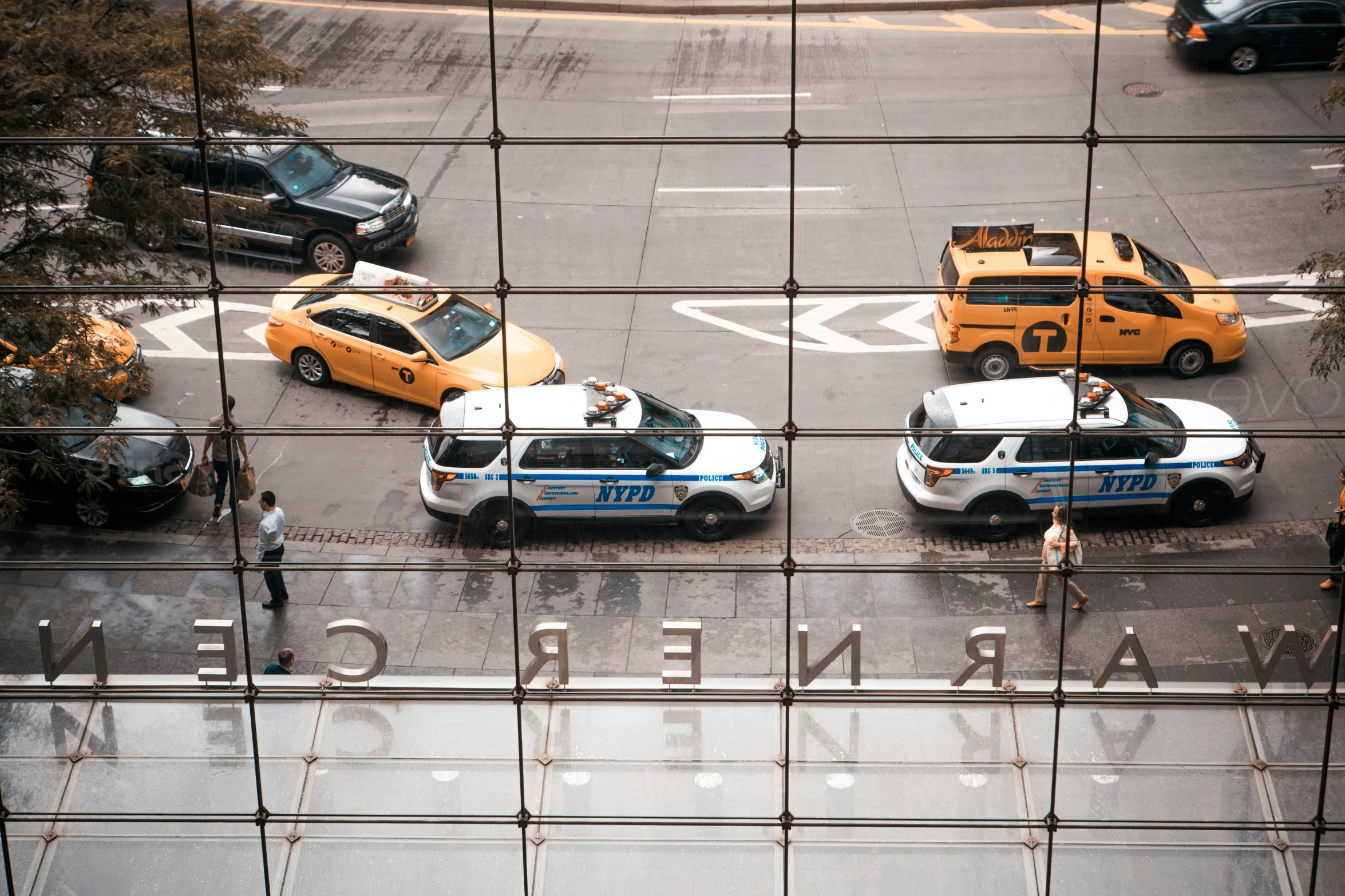 three police cars are lined up behind a fence