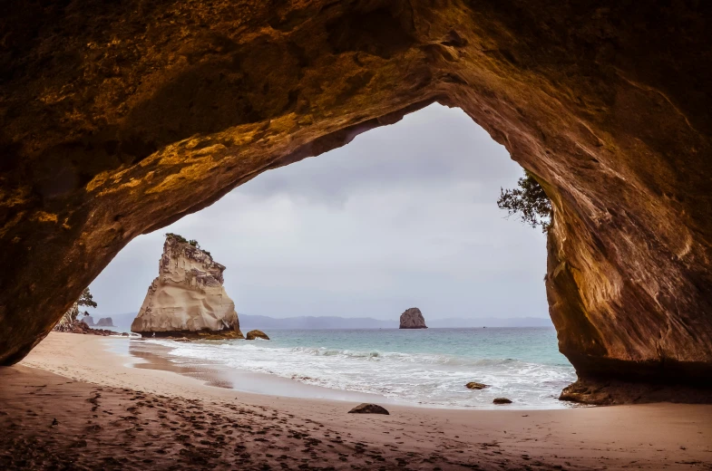 large arch shaped rock formation at a beach