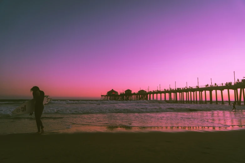 a person on the beach with a surfboard watching the ocean