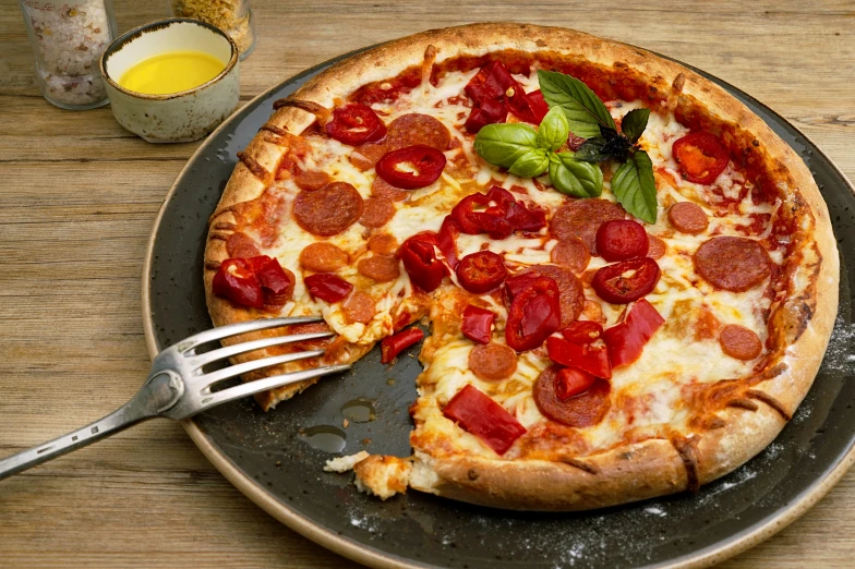 a pizza is on a metal pan with a piece taken out