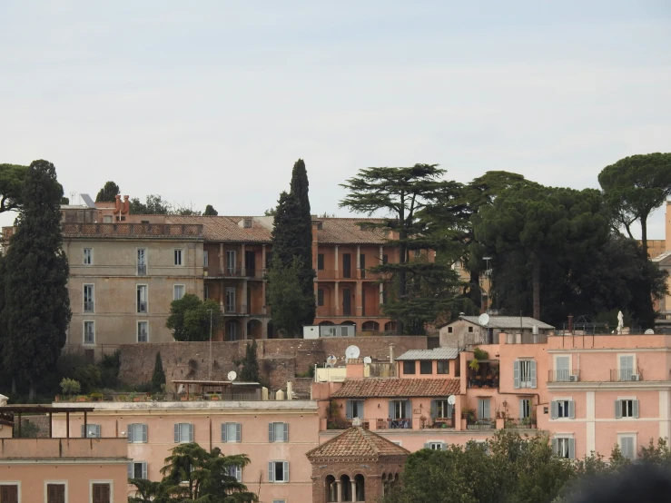 a big building is behind some trees and bushes