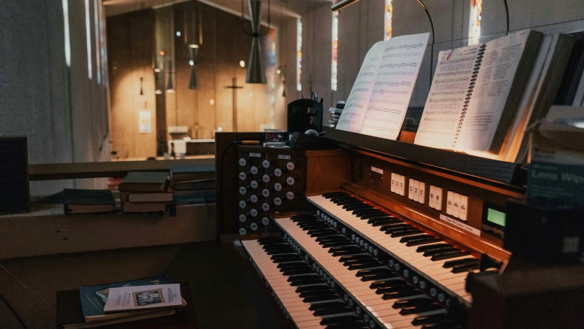 a pipe organ sits in the dark, with musical sheets on top