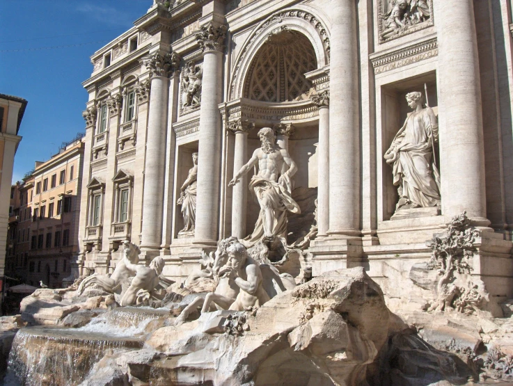 a fountain that has sculptures on it and statues all around