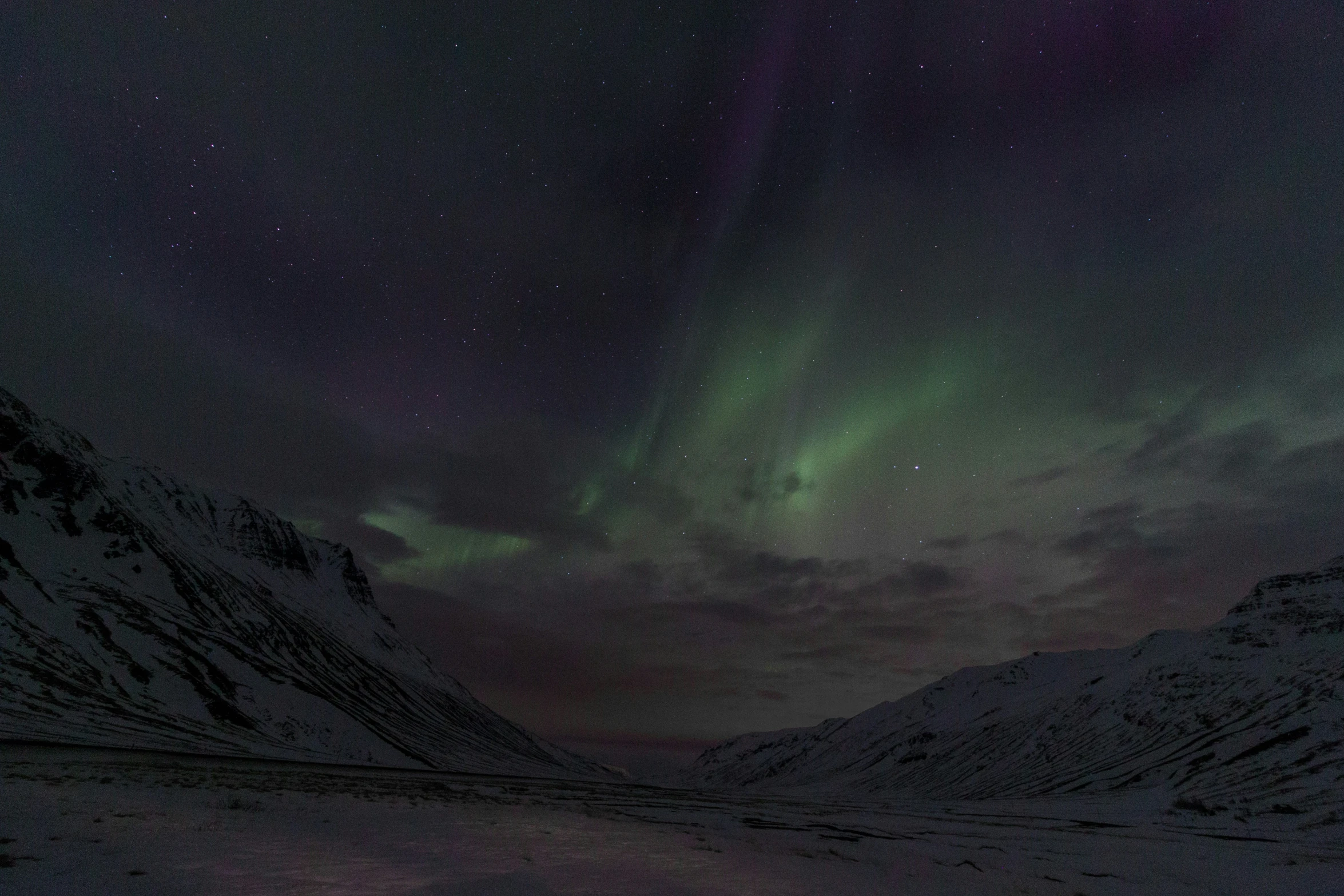 the northern lights glow brightly above snow covered mountains