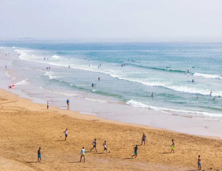 the people are all on the beach and surfing