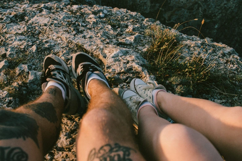 two people sit at the top of a rock outcropping