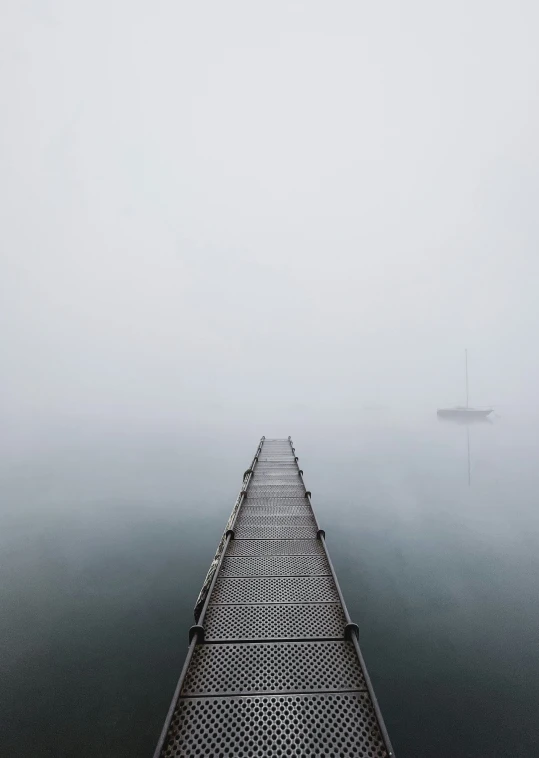 the bridge is on a misty day over water