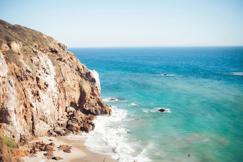 some very pretty blue water and a big hill