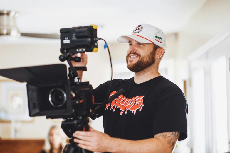 a man standing and holding a camera in his hands