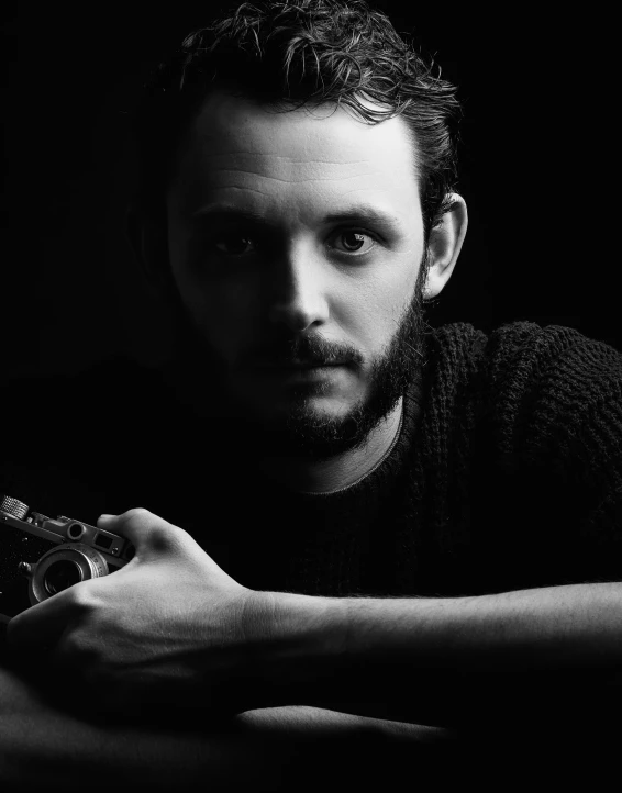 a young man holding a small cell phone