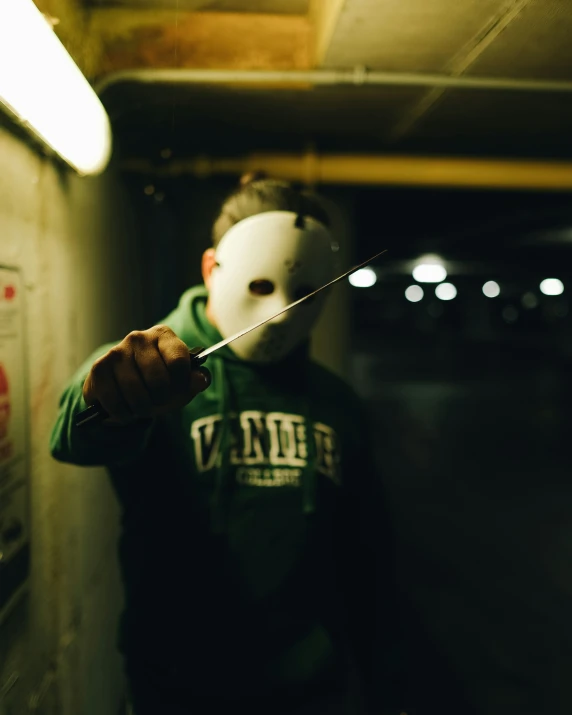 a guy in a green jacket with a white mask on