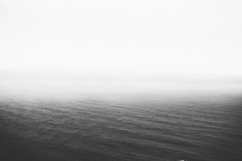 people walking along the ocean in the fog