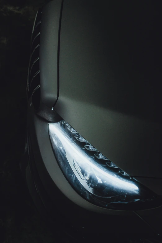 car's hood lights shine bright as it appears to be glowing in the dark