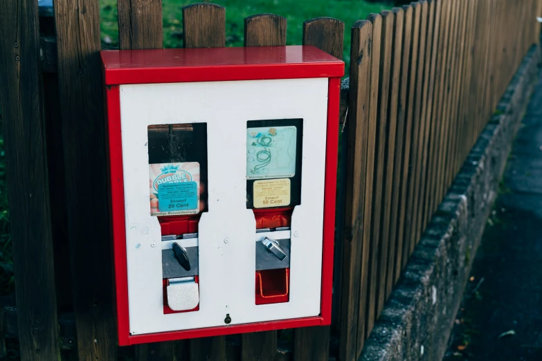 an old style double - sided vending machine by a fence