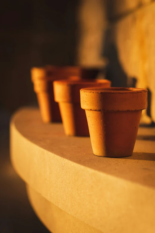 some clay pots are sitting on top of a stone bench