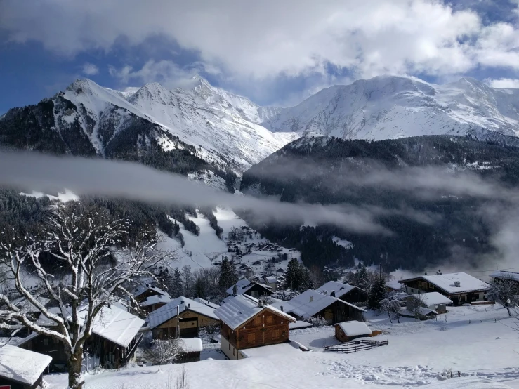 a scenic winter scene, with the clouds coming up over houses