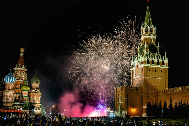 fireworks explode over the city skyline in the dark