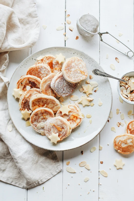 a plate of powdered sugar covered pastries on a table