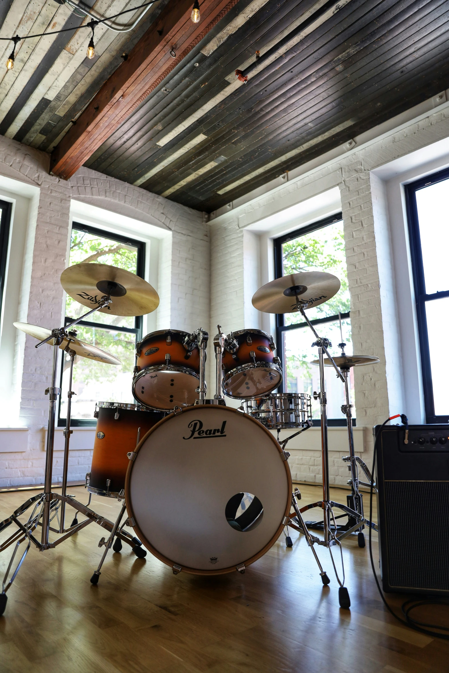 a room with a musical instrument, musical speakers, and drums