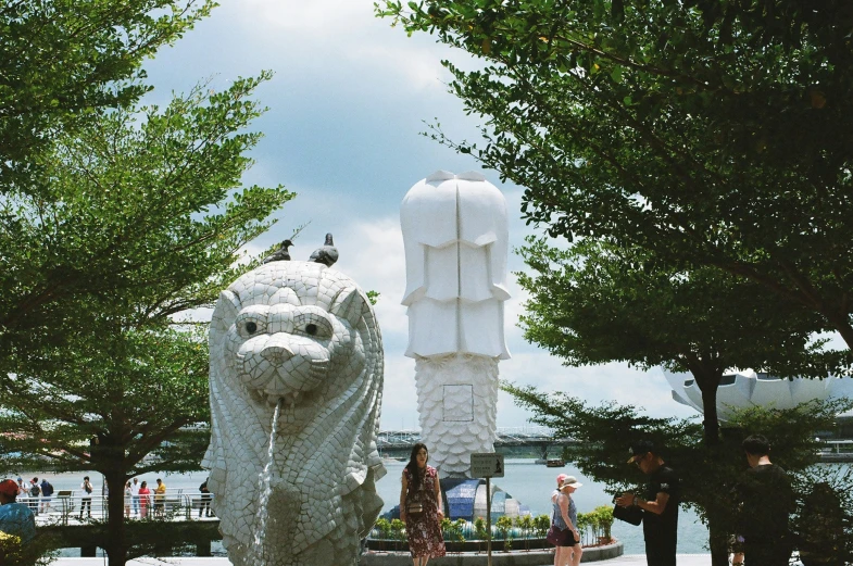 a large animal statue on the ground near trees