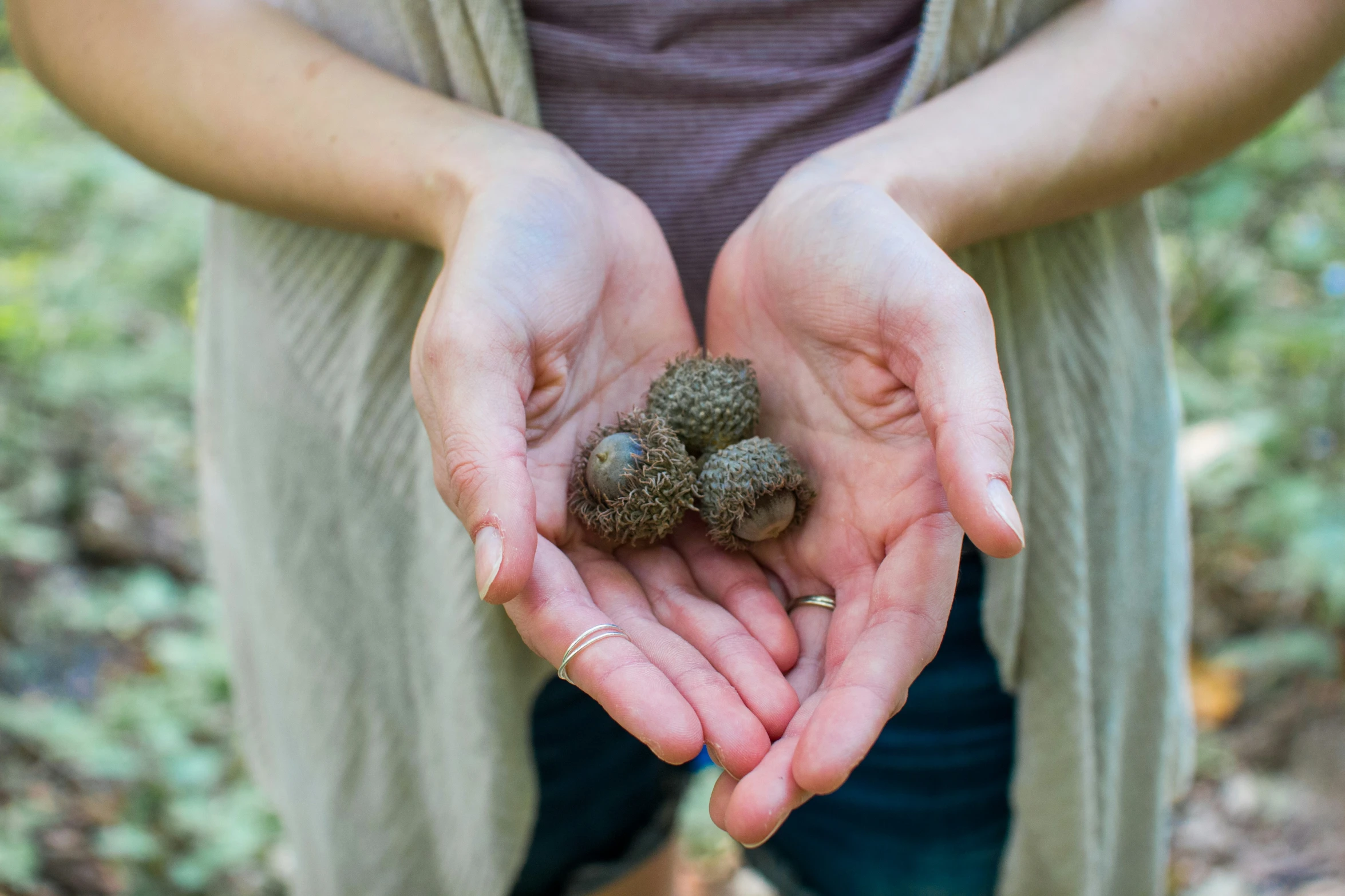 a woman in brown shirt holding a green ball of moss