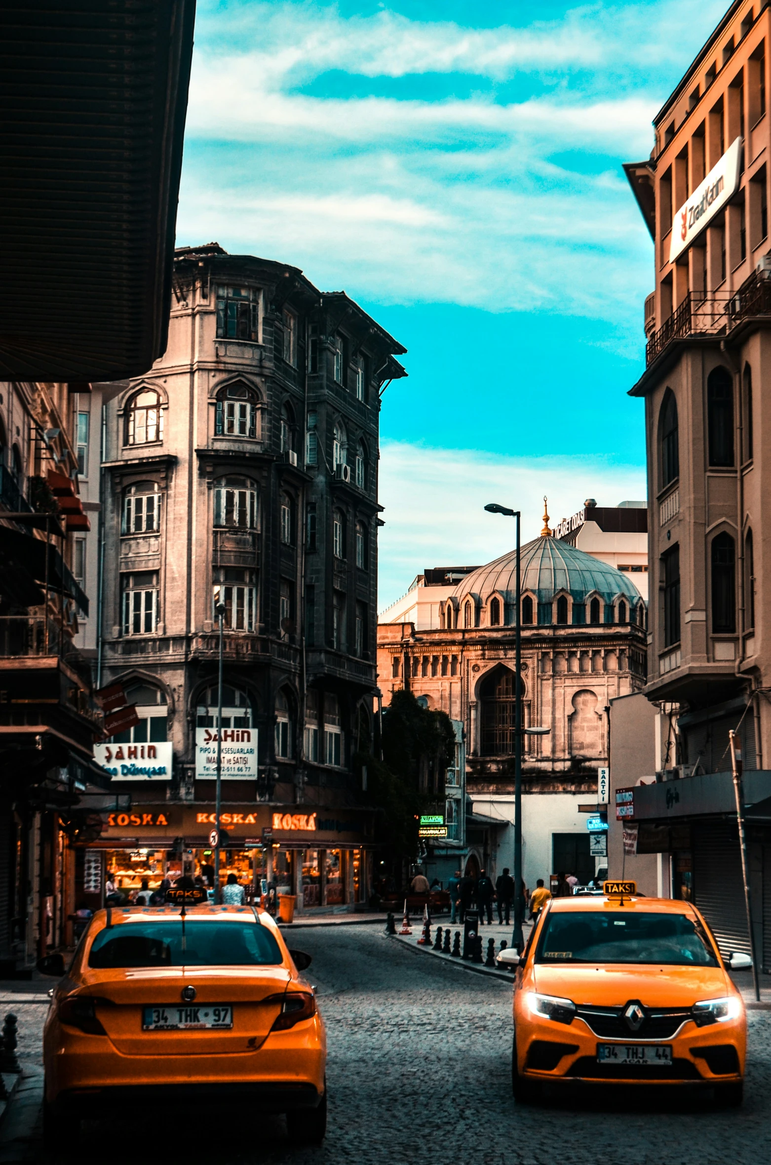 a street lined with tall building next to tall brown buildings