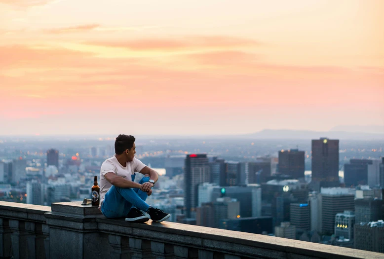 a man sitting on top of a tall building