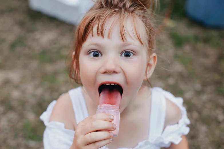 a  wearing white top eating a donut