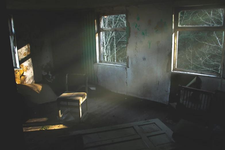 sunlight streaming through two windows into an old looking room