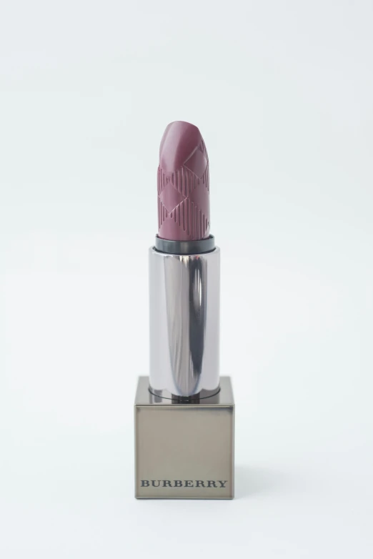 a pink lipstick sitting on top of a metal stand
