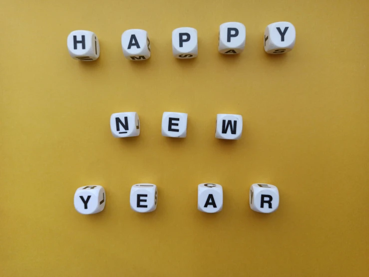 some type of letter tiles with words that spell out happy new year