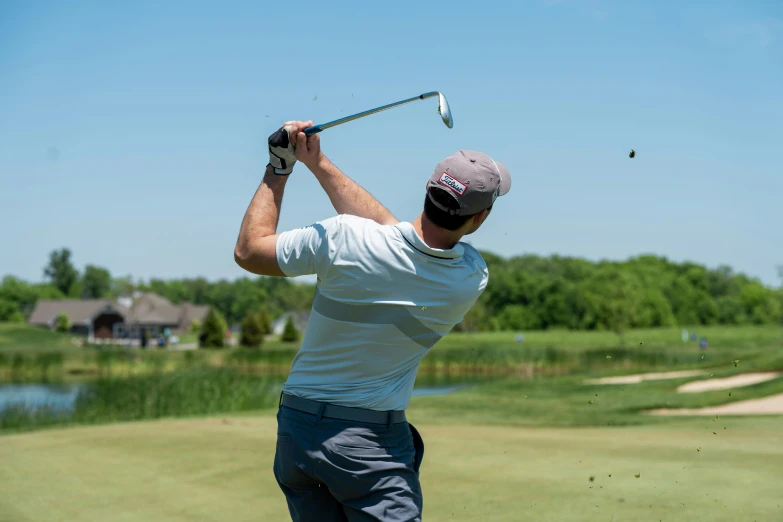 a man is hitting his golf ball with a club