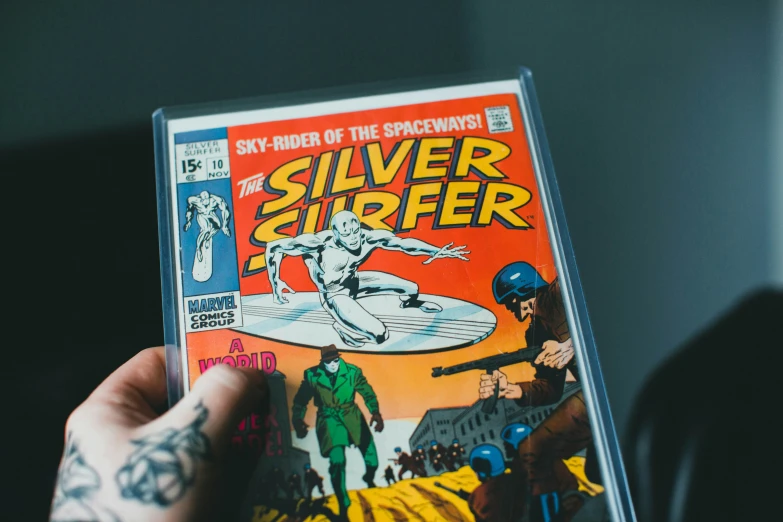 a person holds a comic book up in their hand