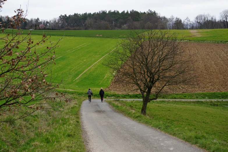 two people walking down a rural road