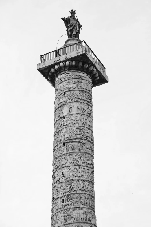 a very tall stone column with a statue at the top