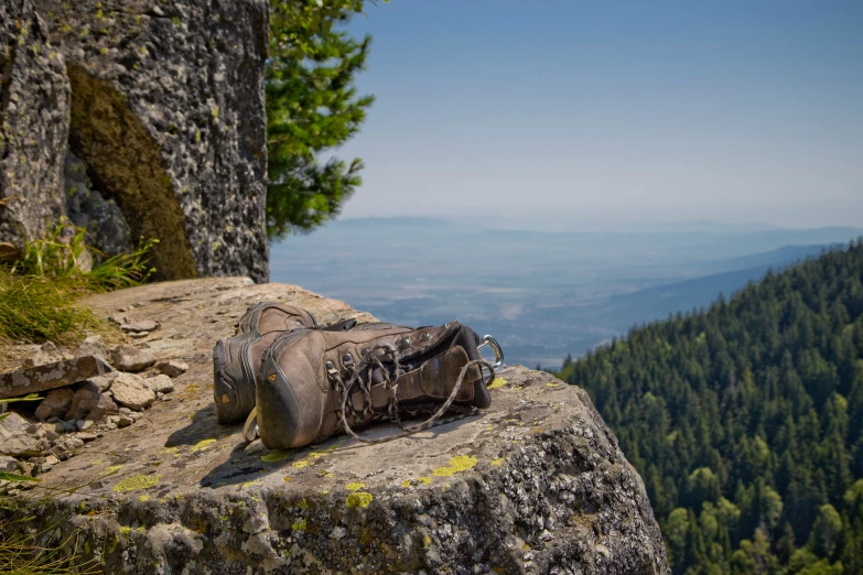 a pair of shoes with a chain are perched on the side of a cliff