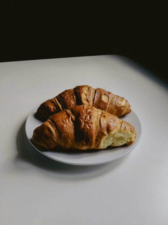 three croissants that are sitting on a white plate