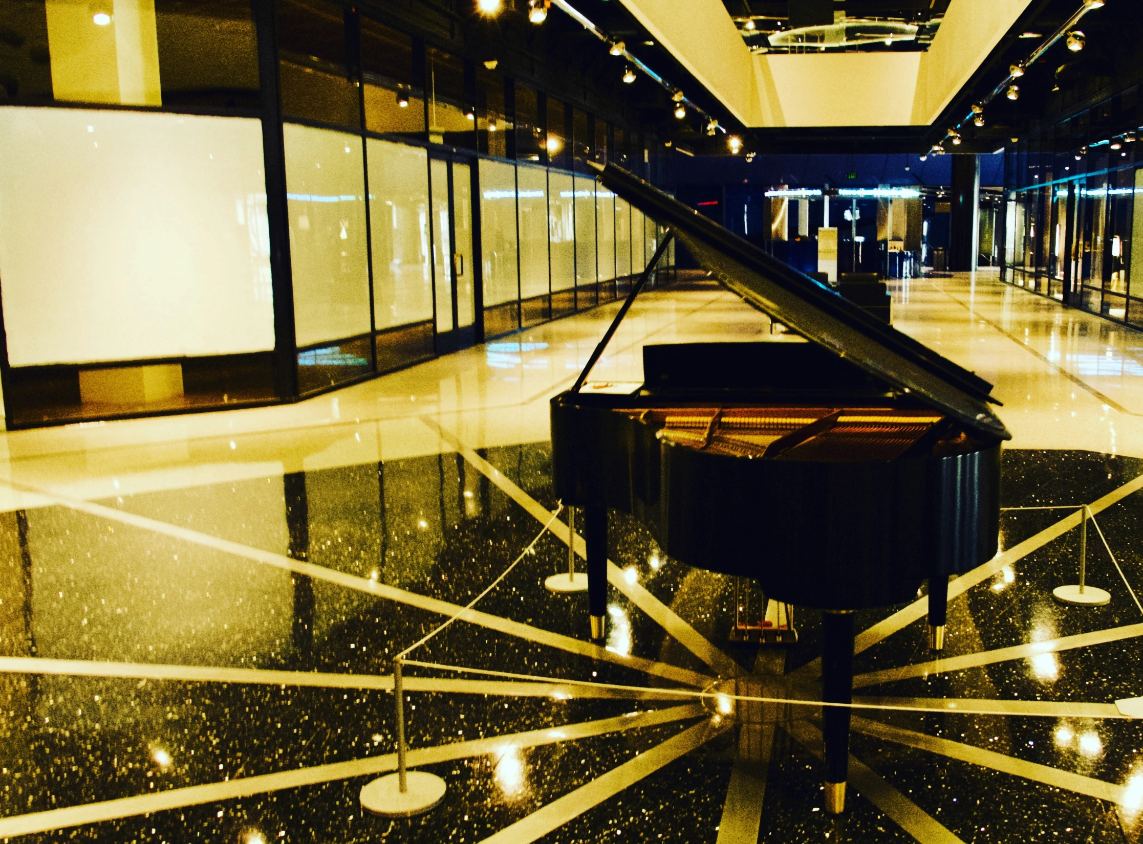 a grand piano sitting in a room next to a wall