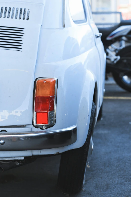 the back view of an old car parked on a street