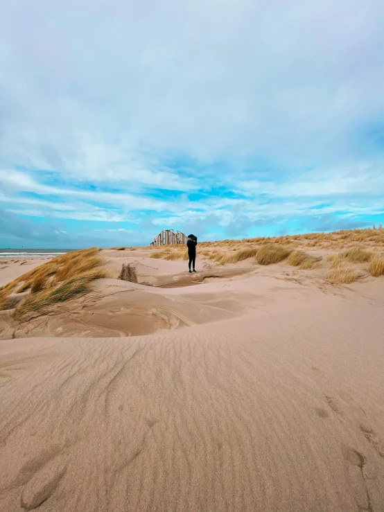 two people standing on top of a sandy field