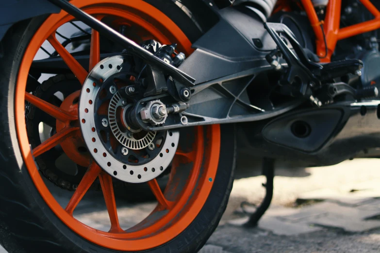 an orange front wheel of a motorcycle on the street