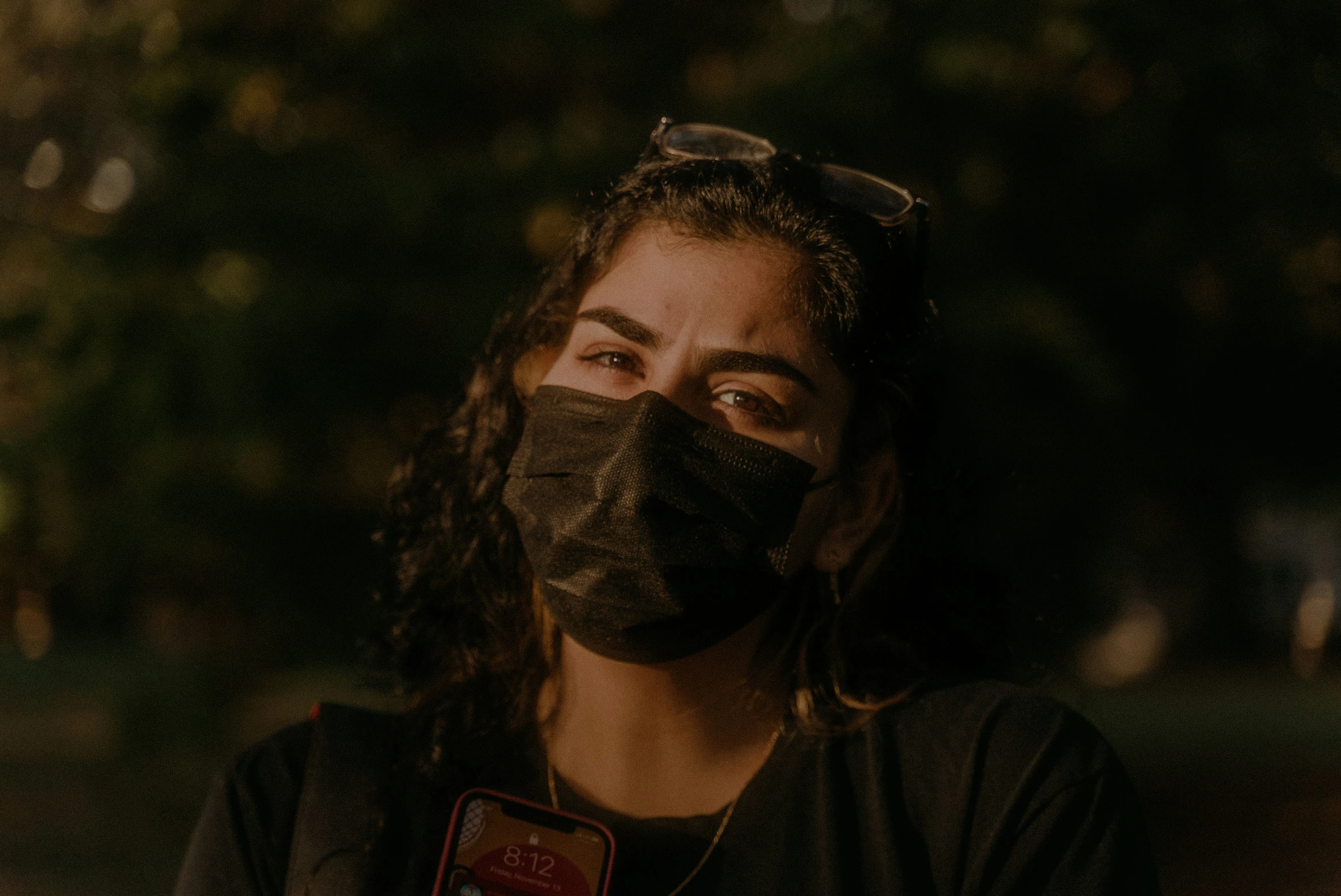 a woman with sunglasses and a black mask