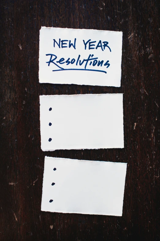 a piece of paper that says new year resolutions next to each other