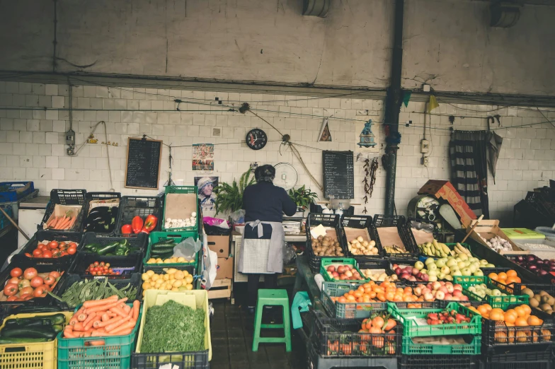 a person walking through a store with fruit on display