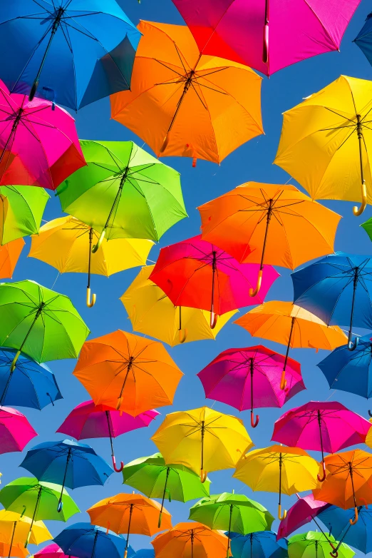 a large number of multicolored umbrellas flying in the air